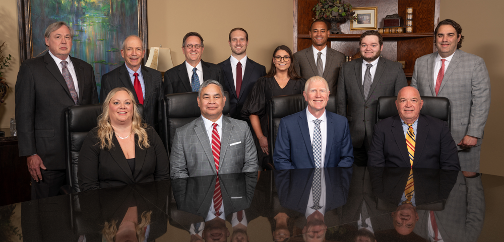 group photo of the attorneys at Hiltgen & Brewer, P.C., in their conference room