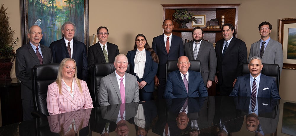 Group photo of attorneys at Hiltgen & Brewer, P.C., in their conference room